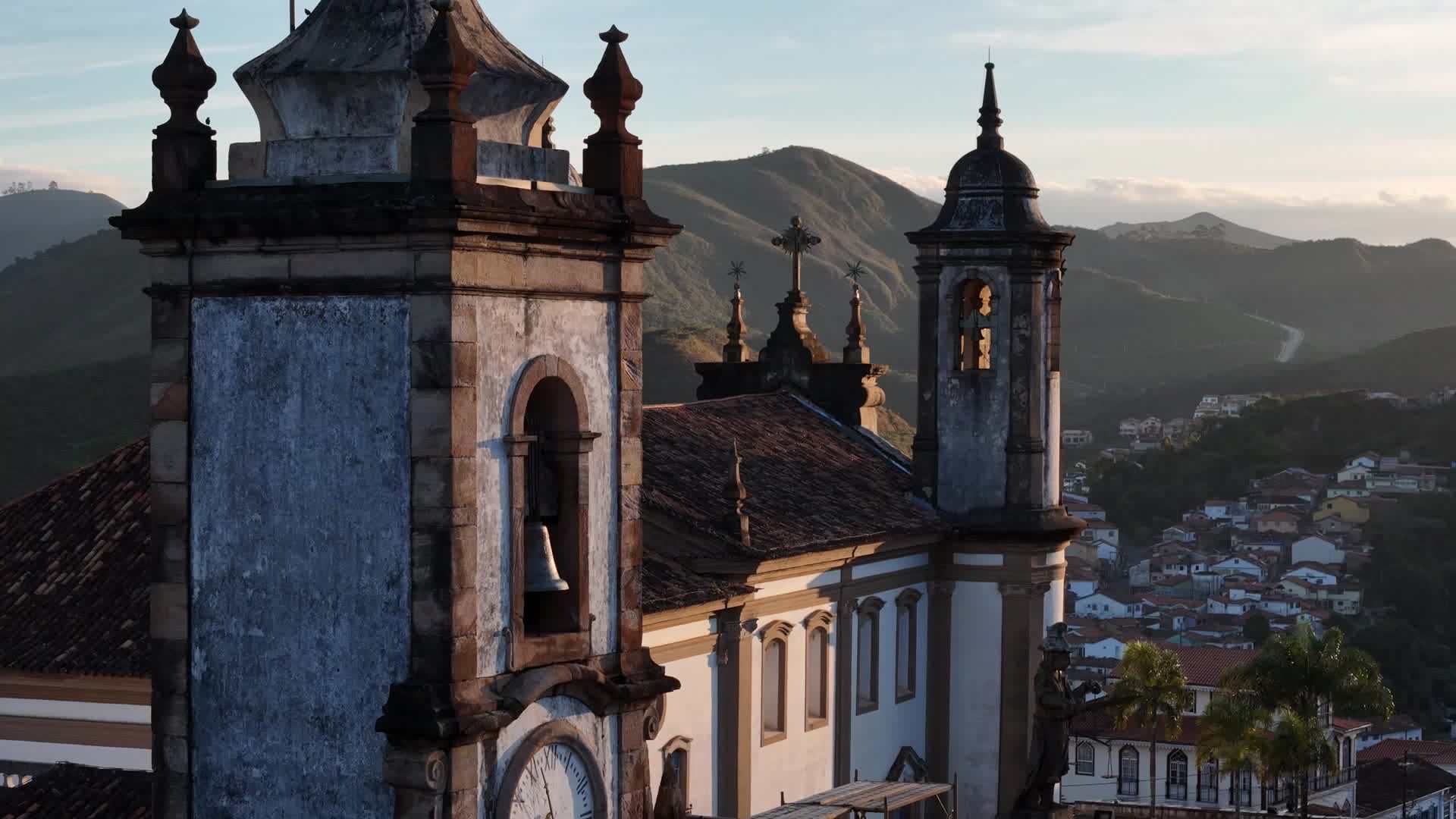 Torres de igreja barroca ao entardecer sobre o casario de Ouro Preto